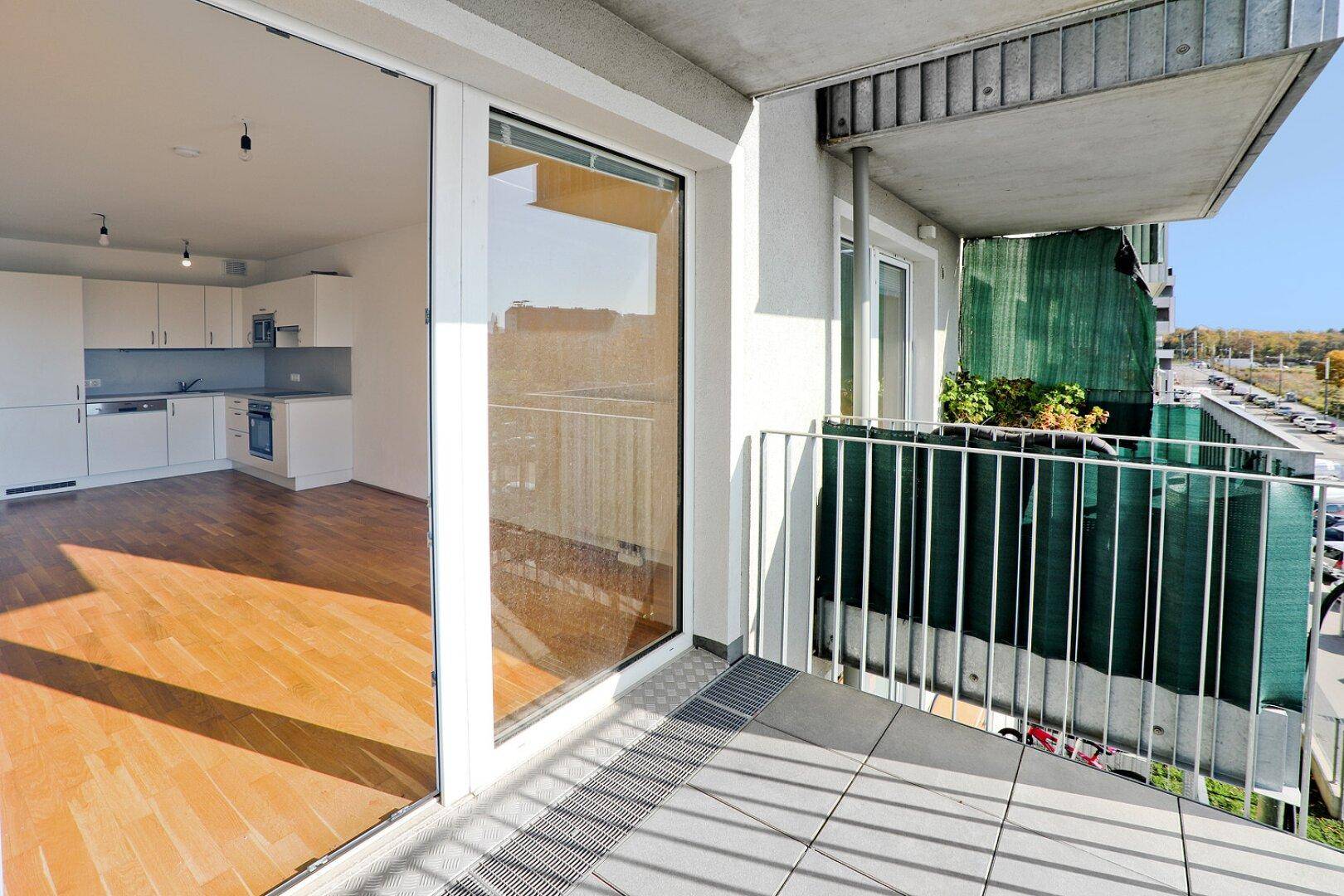 Geräumiger Balkon mit Fliesenboden und Blick auf die Umgebung.