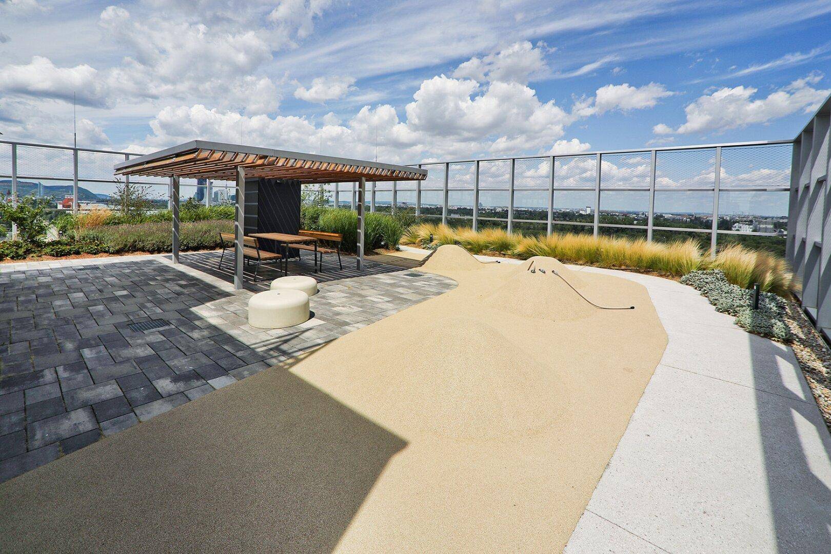 Großzügige Dachterrasse mit Pergola, Sitzgelegenheiten und Panoramablick über die Umgebung.