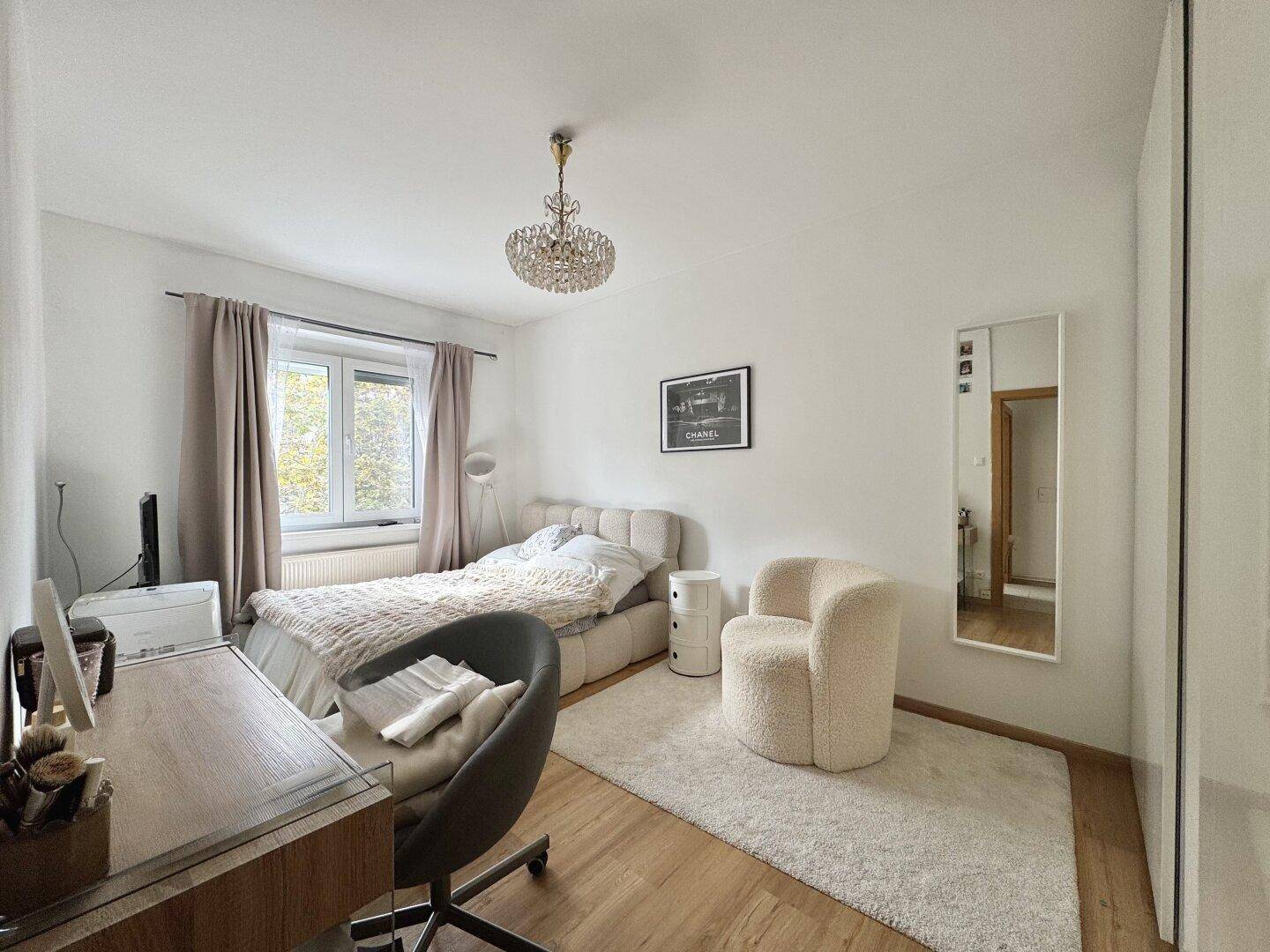Gemütliches Schlafzimmer mit Doppelbett, Schreibtisch und einem großen Fenster.