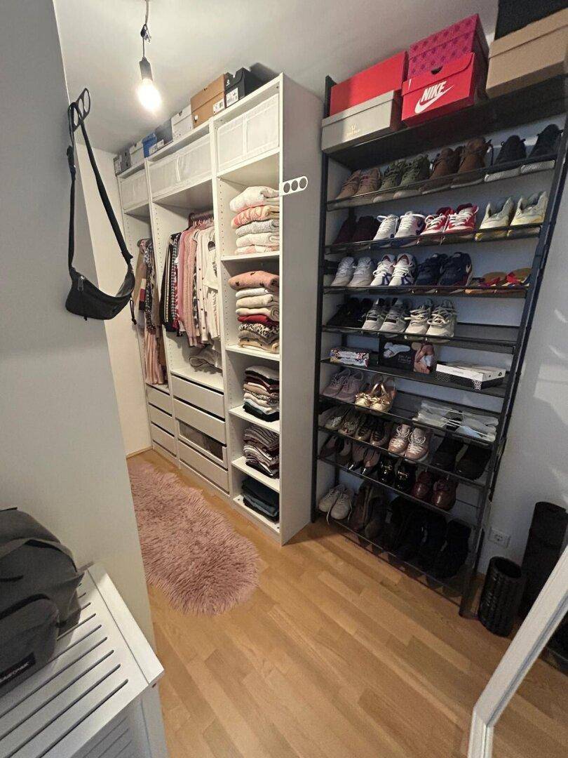 Geräumiger begehbarer Kleiderschrank mit viel Stauraum für Kleidung und Schuhe.