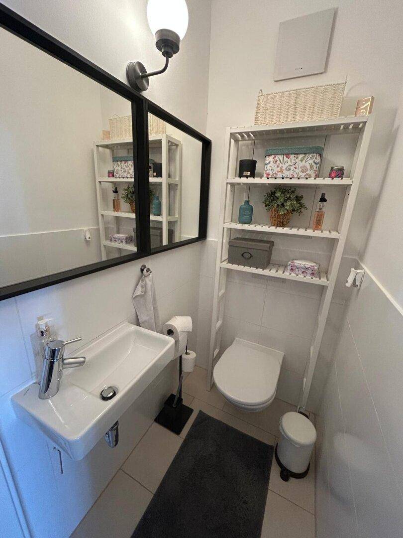 Kleines Gäste-WC mit modernem Waschbecken, Toilette und Wandspiegel für Besucher.