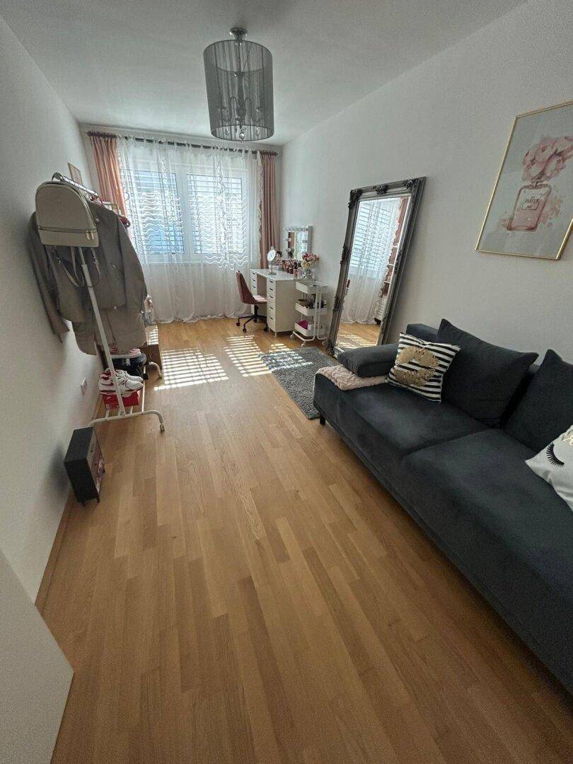 Vielseitiger Raum mit Sofa, Schreibtisch und großem Spiegel, ideal als Schlaf- oder Arbeitszimmer.