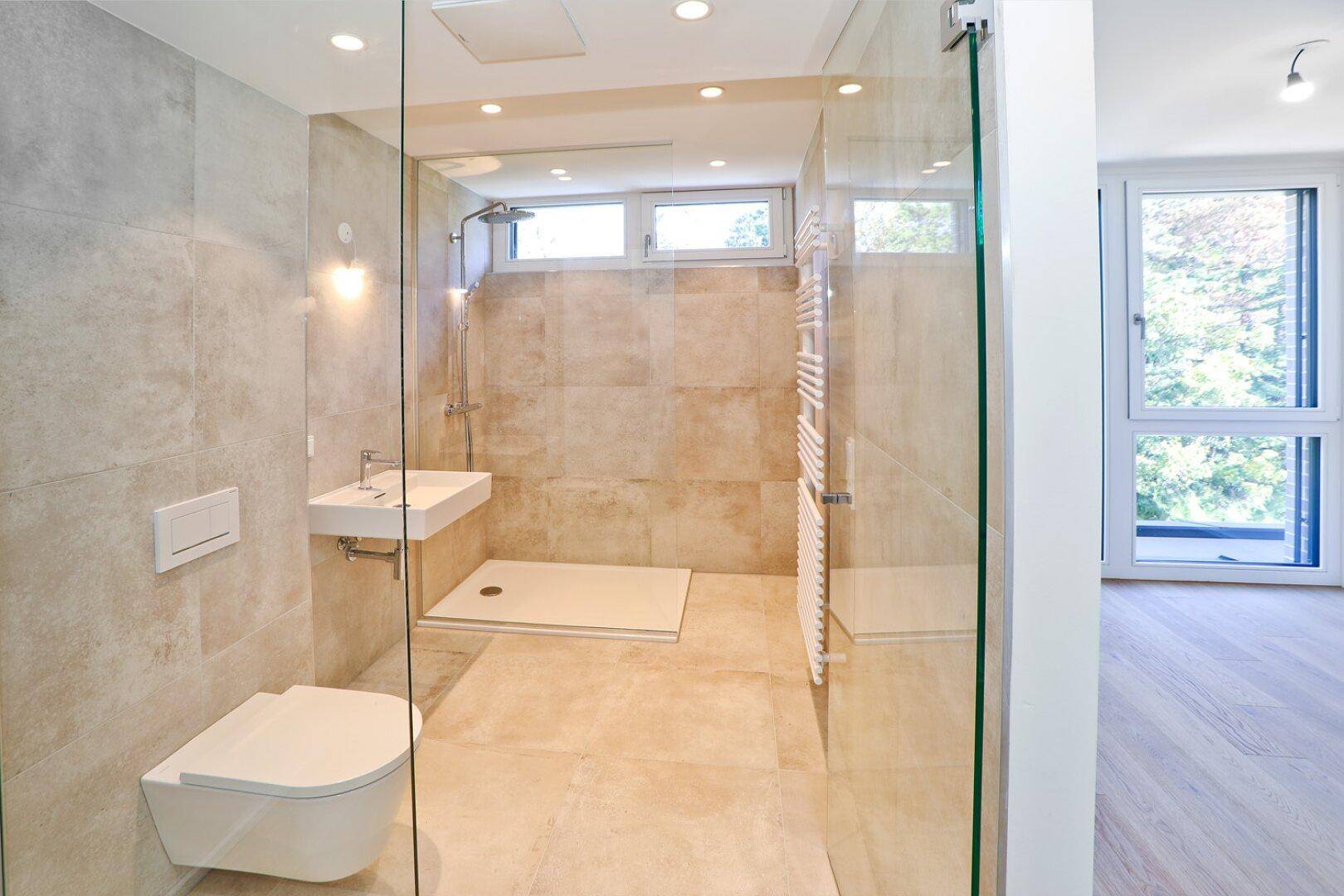 Modernes Badezimmer mit begehbarer Dusche, Wand-WC, Waschbecken und beheiztem Handtuchhalter.