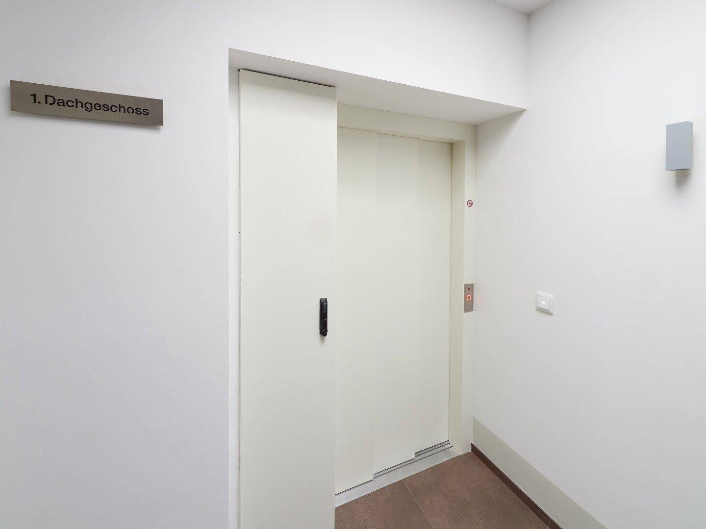 Moderner Aufzug im Treppenhaus, der bequemen Zugang zu den oberen Etagen ermöglicht.