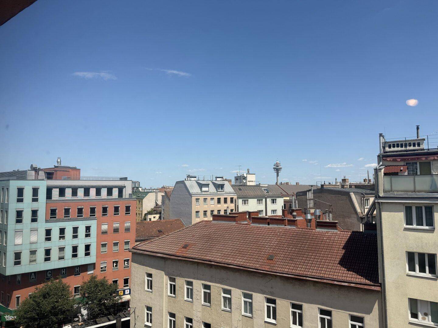 Panoramablick über die städtische Skyline mit verschiedenen Gebäuden und blauem Himmel.