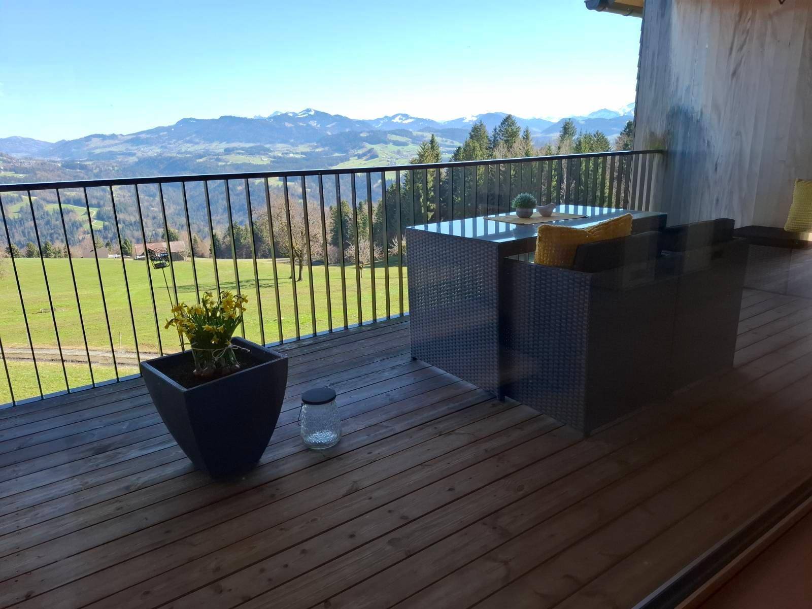 Balkon mit Sitzgelegenheiten und atemberaubendem Panoramablick auf die Berge und grüne Täler.