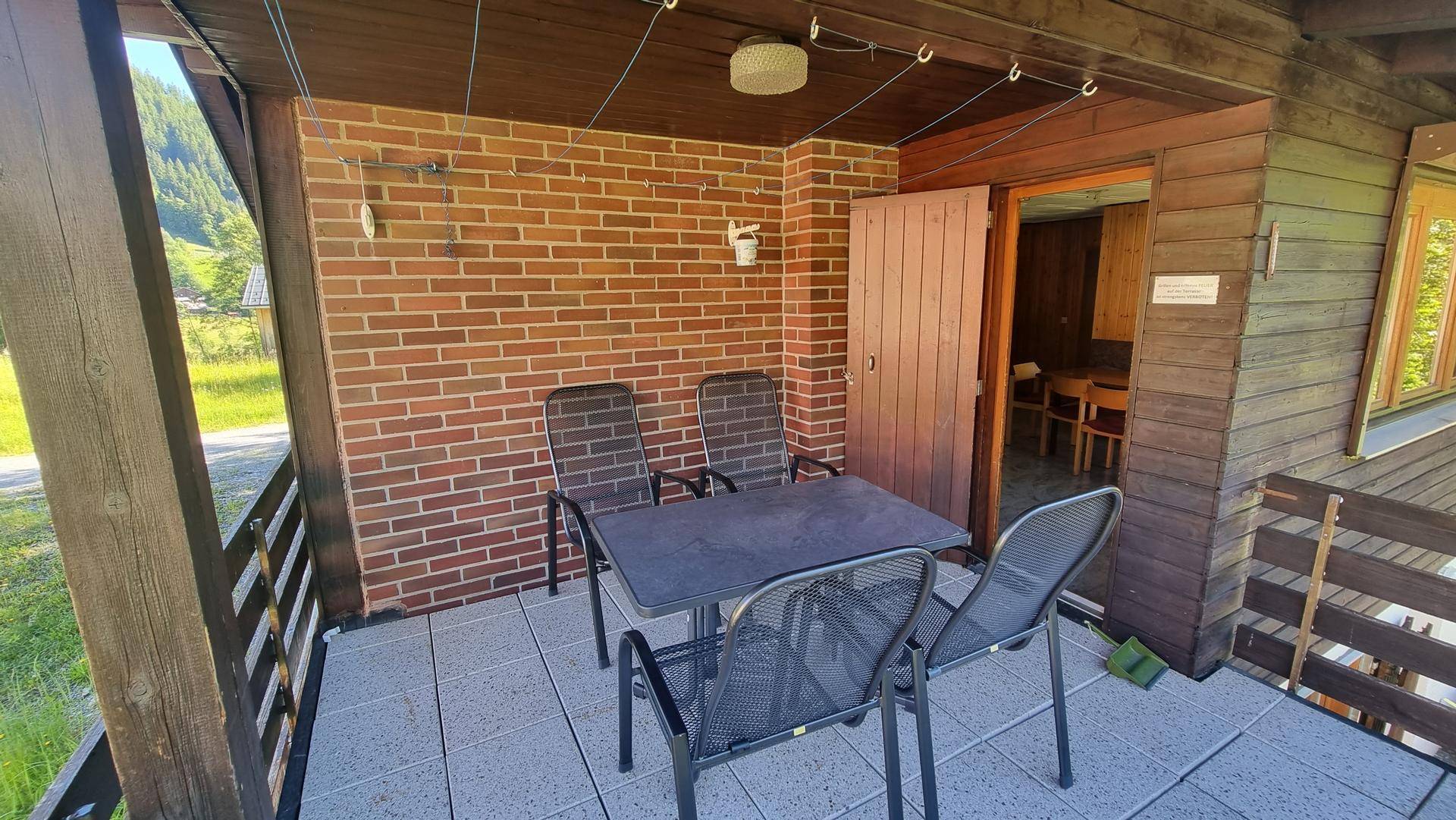 Gemütlicher Balkon mit Sitzgelegenheiten und Blick auf die umliegende Natur und Berge.