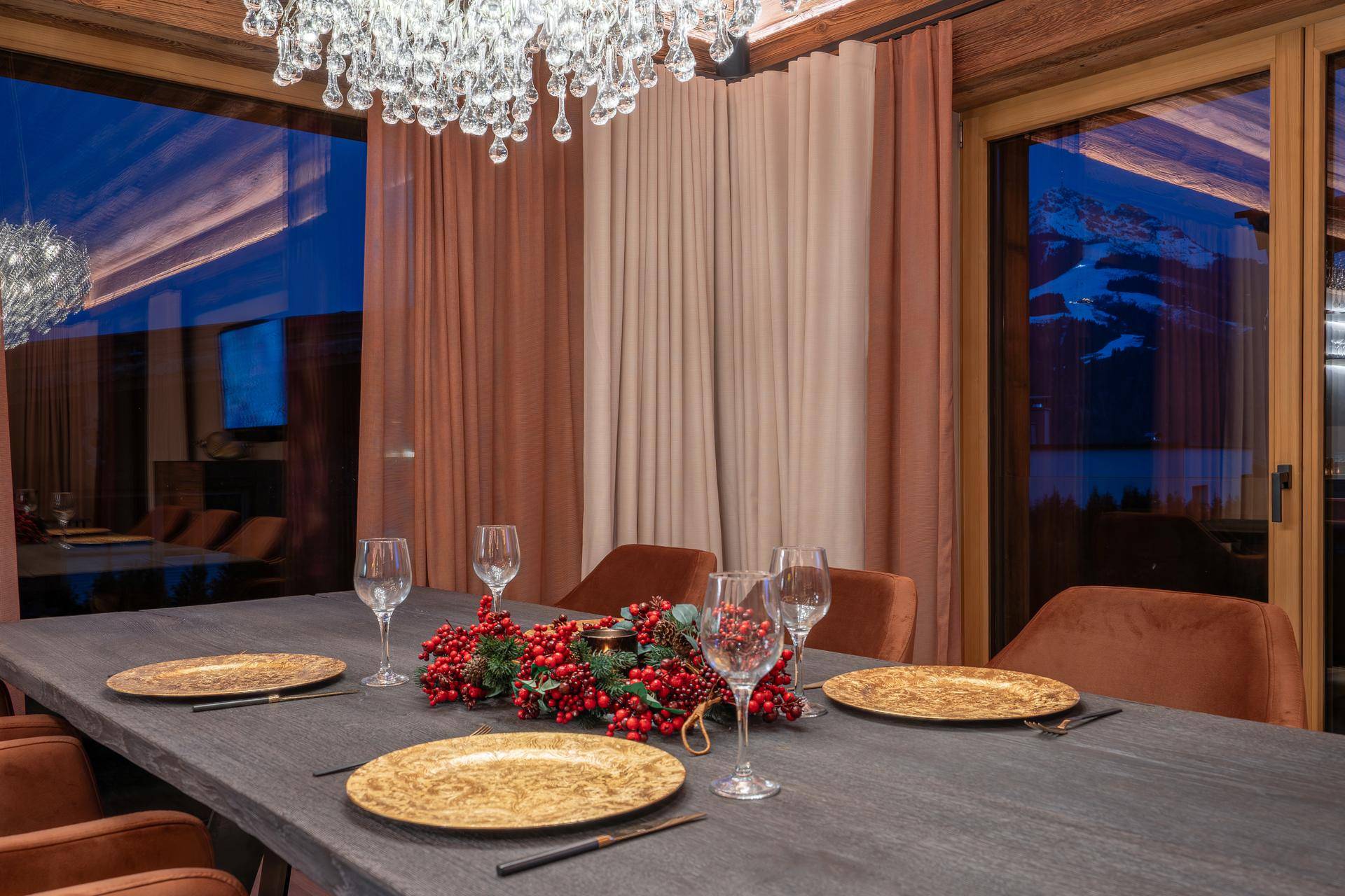 Elegante Esstafel mit festlicher Dekoration und Blick durch große Fenster in die Abenddämmerung.