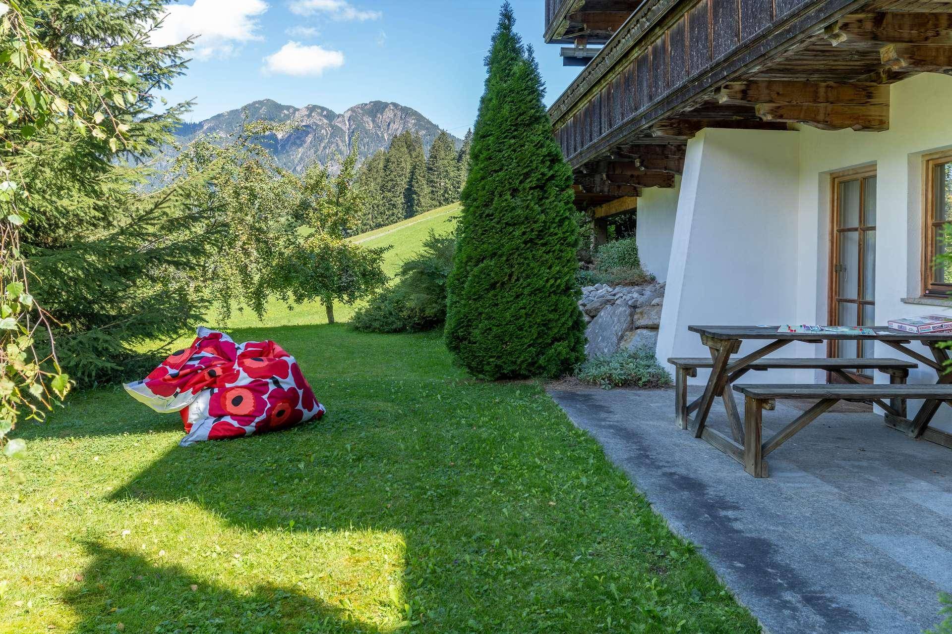 Gepflegter Gartenbereich mit Rasenfläche, Picknicktisch und beeindruckendem Bergblick.