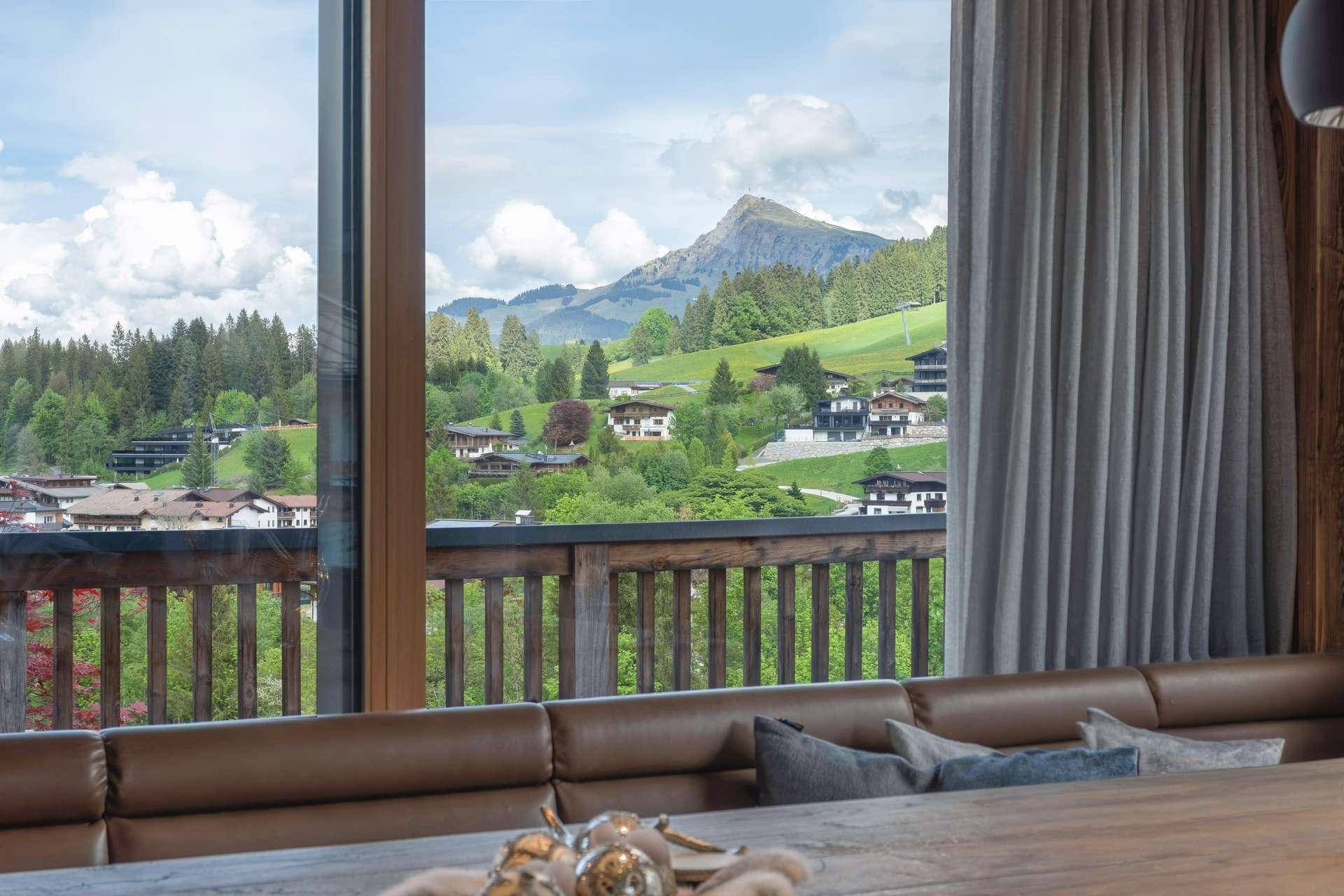 Essbereich mit großem Fenster und beeindruckendem Blick auf die umliegende Berglandschaft.
