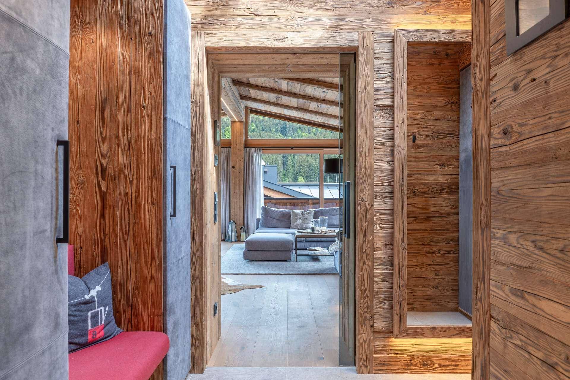 Heller Flur mit Holzwänden und Blick in den offenen Wohnbereich.