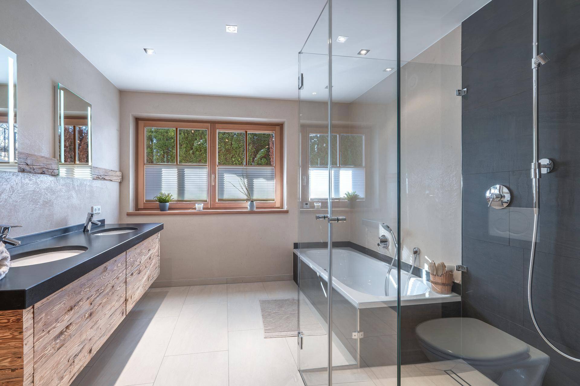Modernes Badezimmer mit Doppelwaschbecken, Badewanne und separater Dusche.