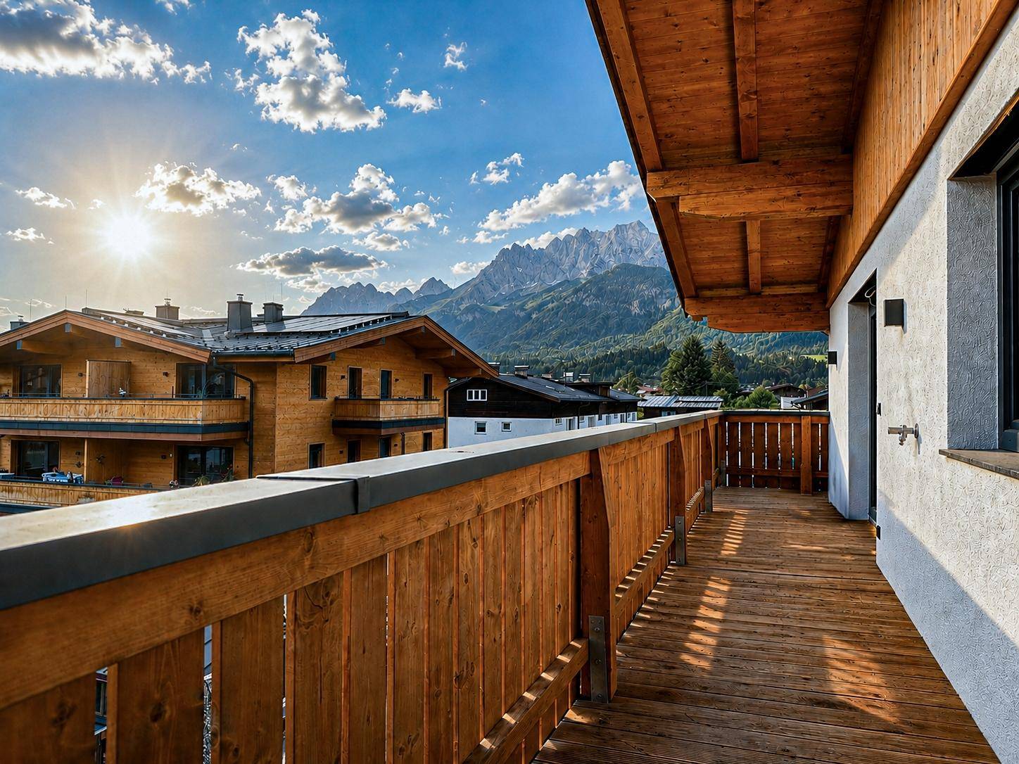 Sonniger Balkon mit Holzgeländer und Holzboden, bietet einen weiten Blick auf die Berge.