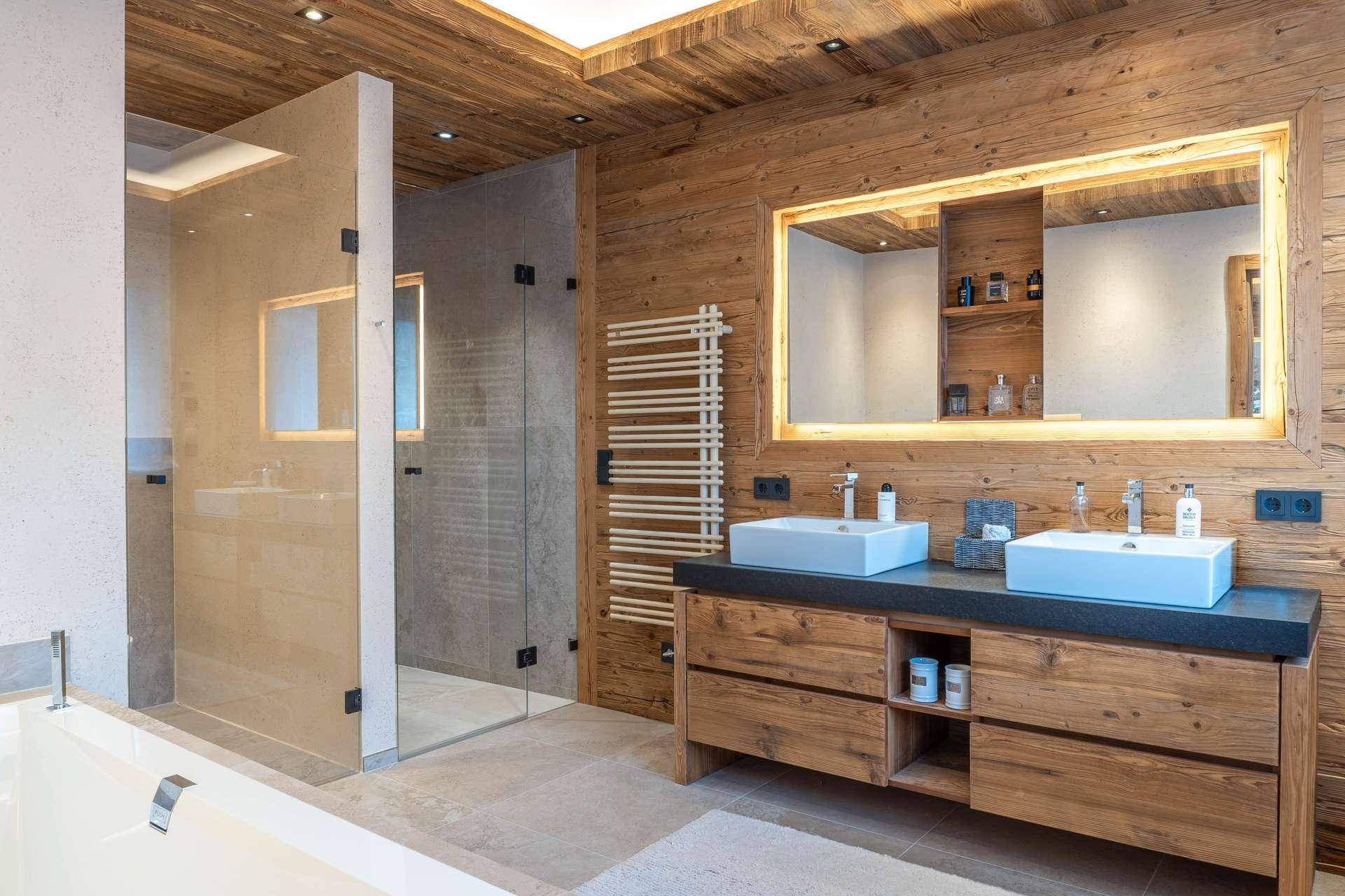 Modernes Badezimmer mit Doppelwaschbecken, begehbarer Dusche und Holzakzenten.
