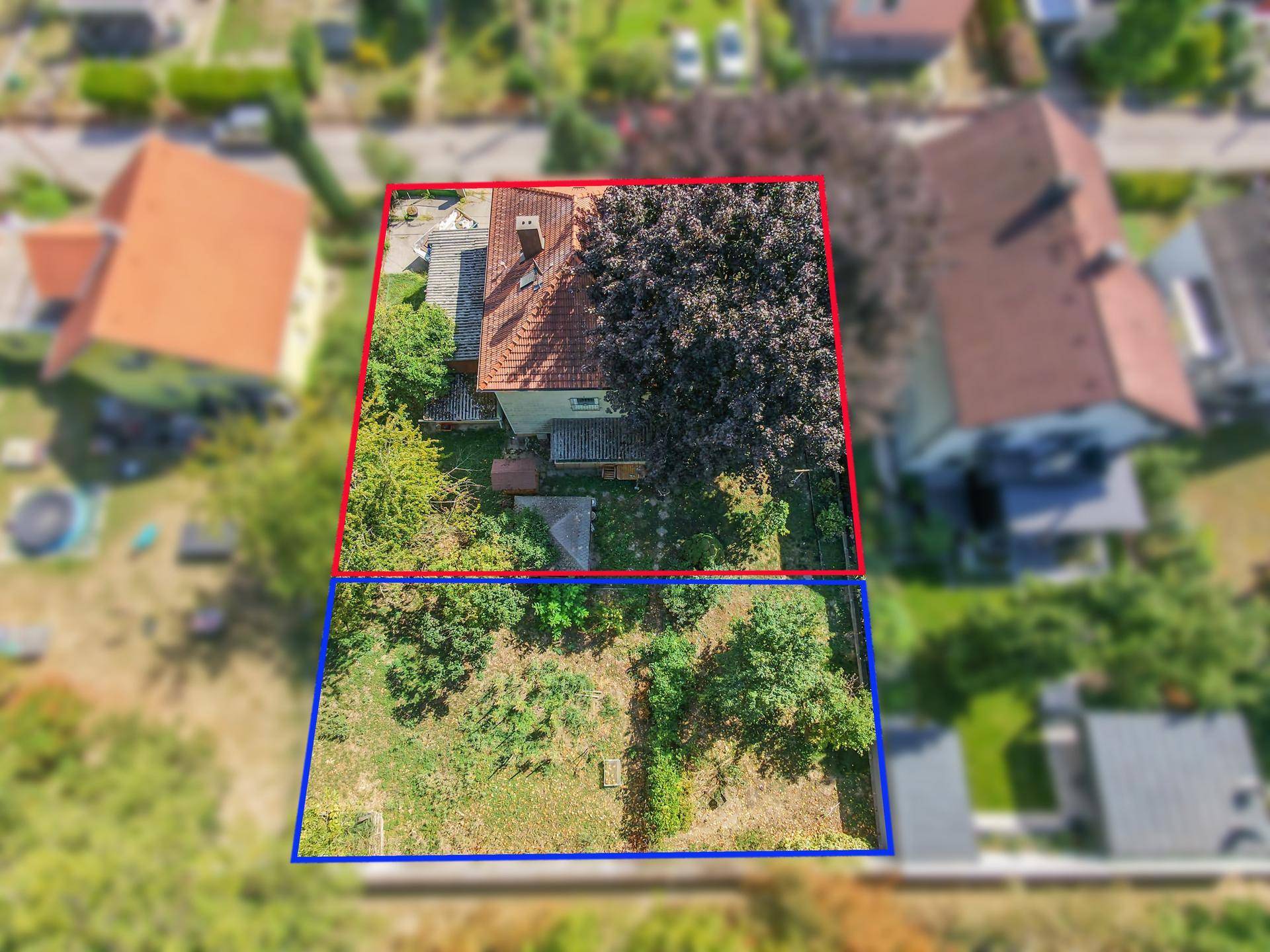 Seitenansicht eines Einfamilienhauses mit großem Garten und angrenzendem Grundstück.