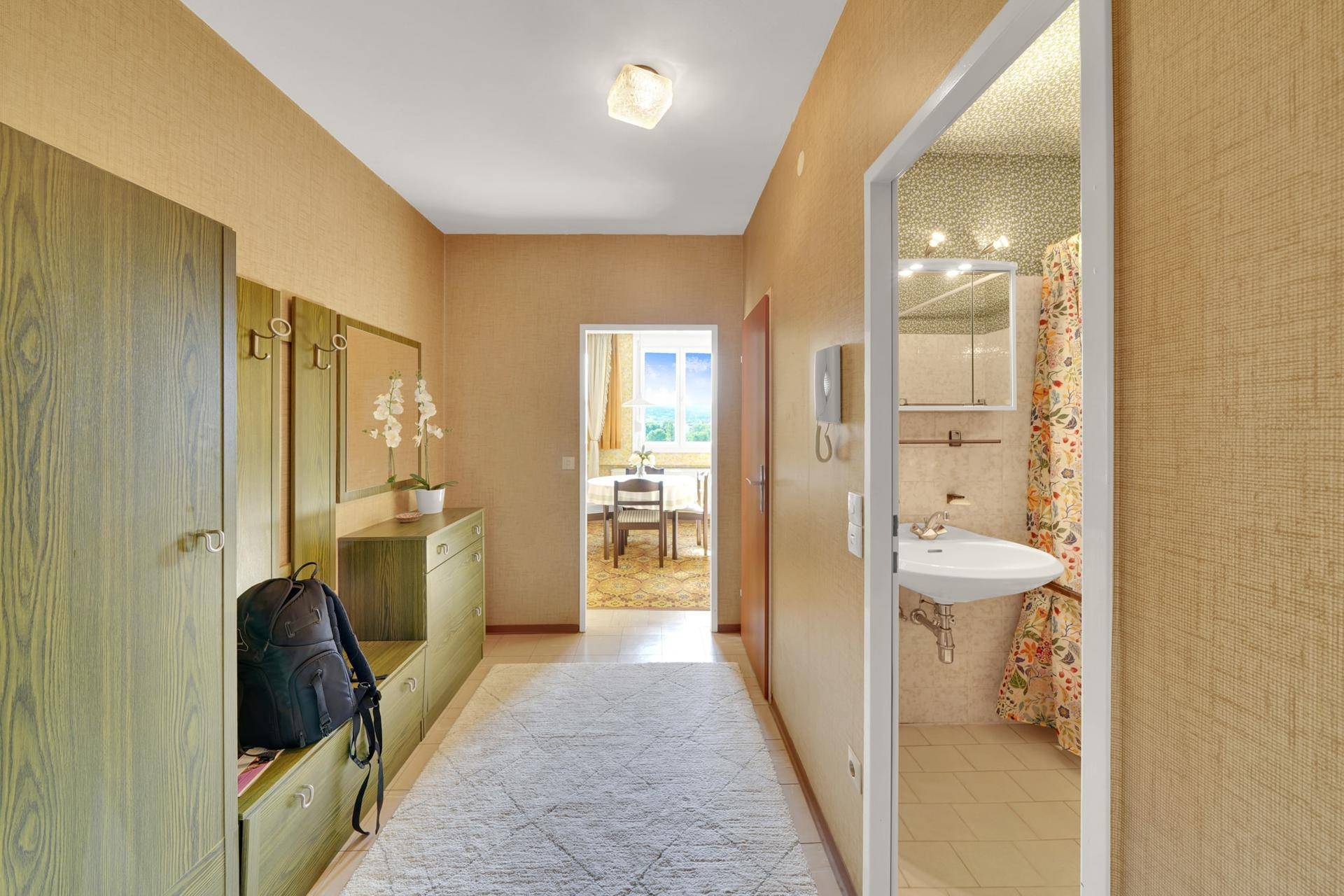 Heller Flur mit Garderobe und Blick in das Esszimmer und Badezimmer.