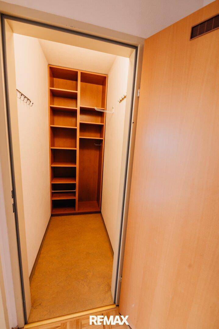 Praktischer Abstellraum mit eingebauten Holzregalen für zusätzlichen Stauraum.