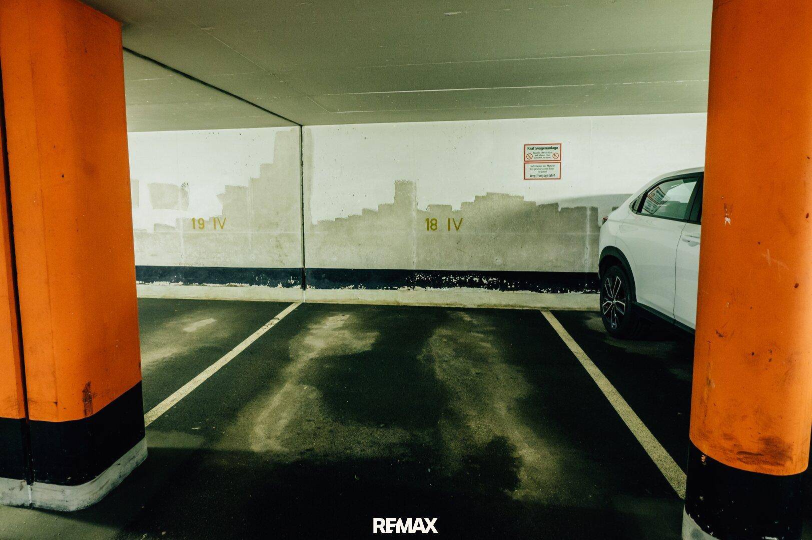 Tiefgarage mit markierten Stellplätzen und einem geparkten Fahrzeug.