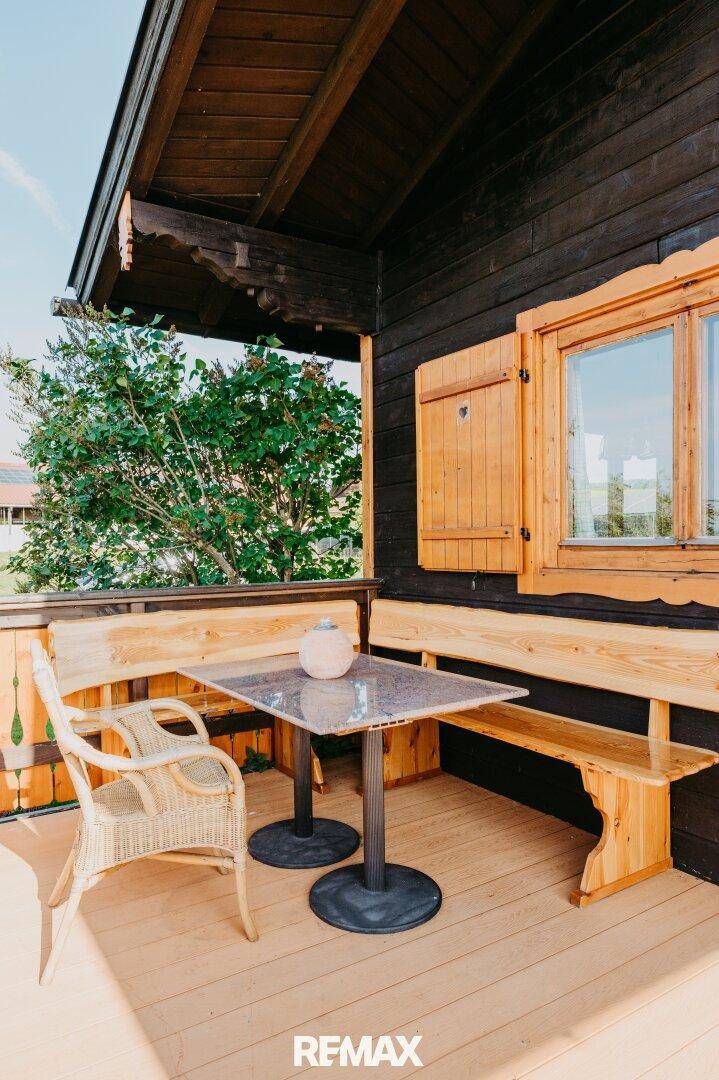 Gemütliche Holzterrasse mit Sitzgelegenheiten und Blick ins Grüne.