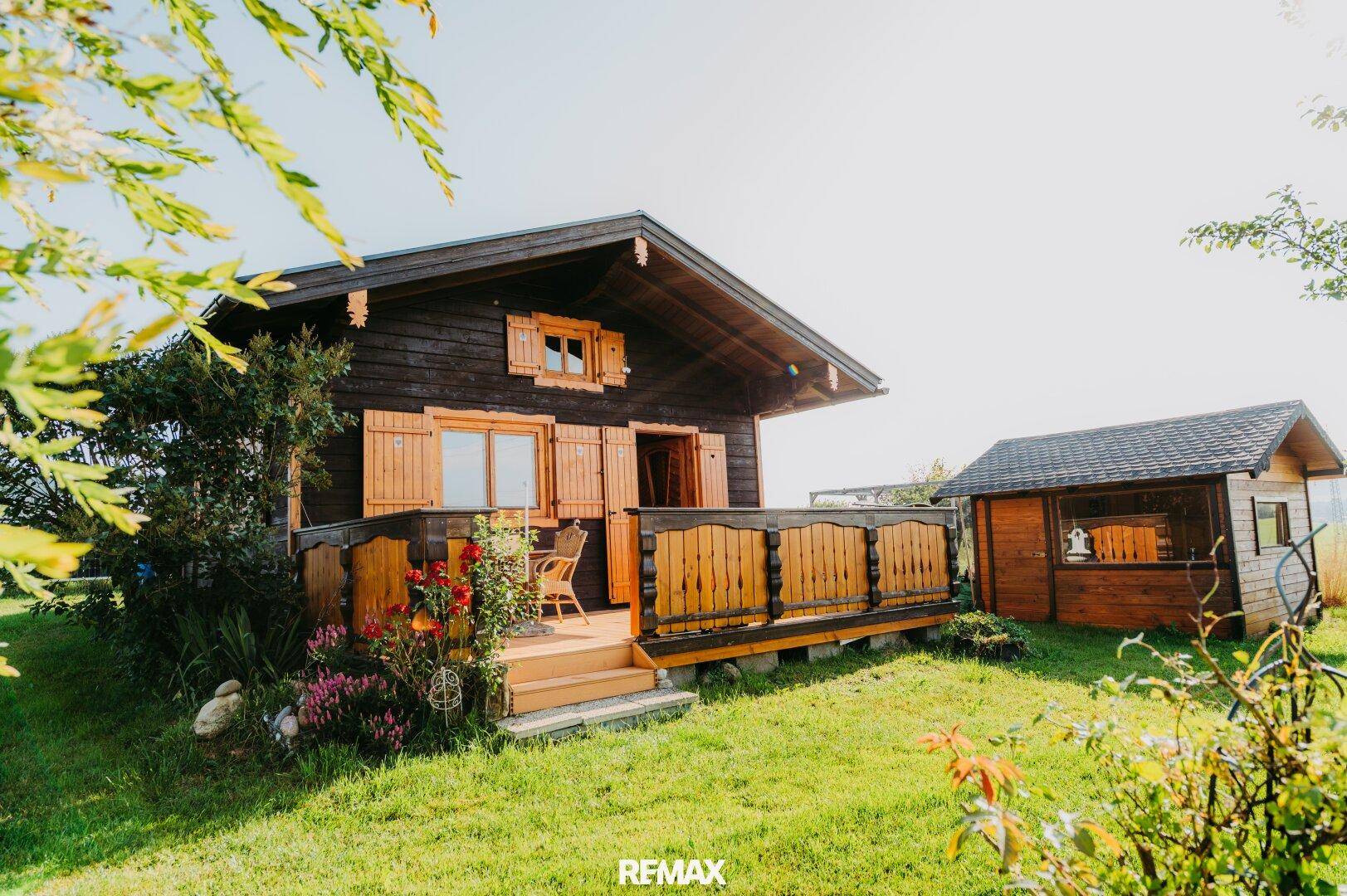 Gesamtansicht des Holzchalets und des Nebengebäudes in ländlicher Umgebung.