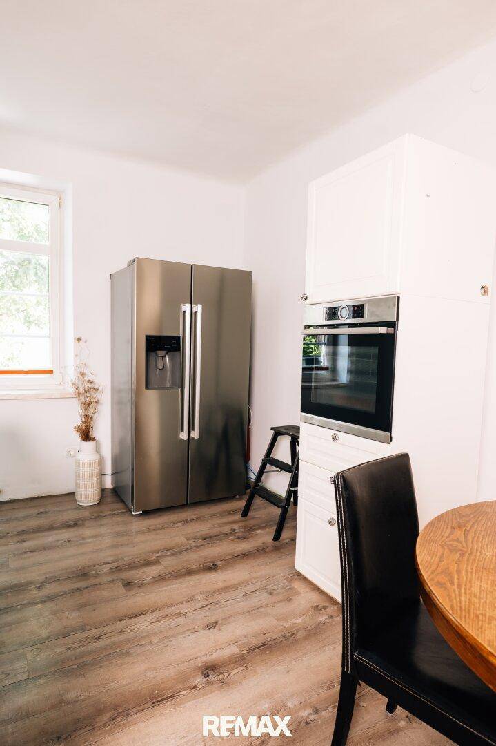 Integrierter Backofen und großer Kühlschrank in der hellen Küche.