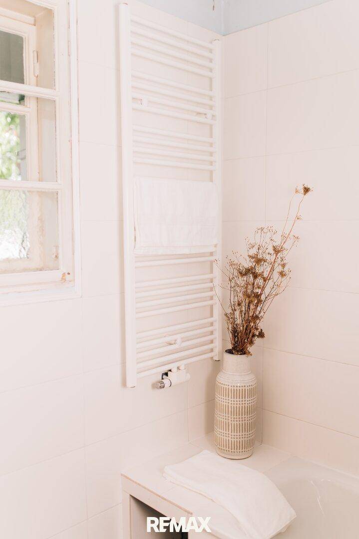 Beheizter Handtuchhalter im Badezimmer neben dem Fenster.