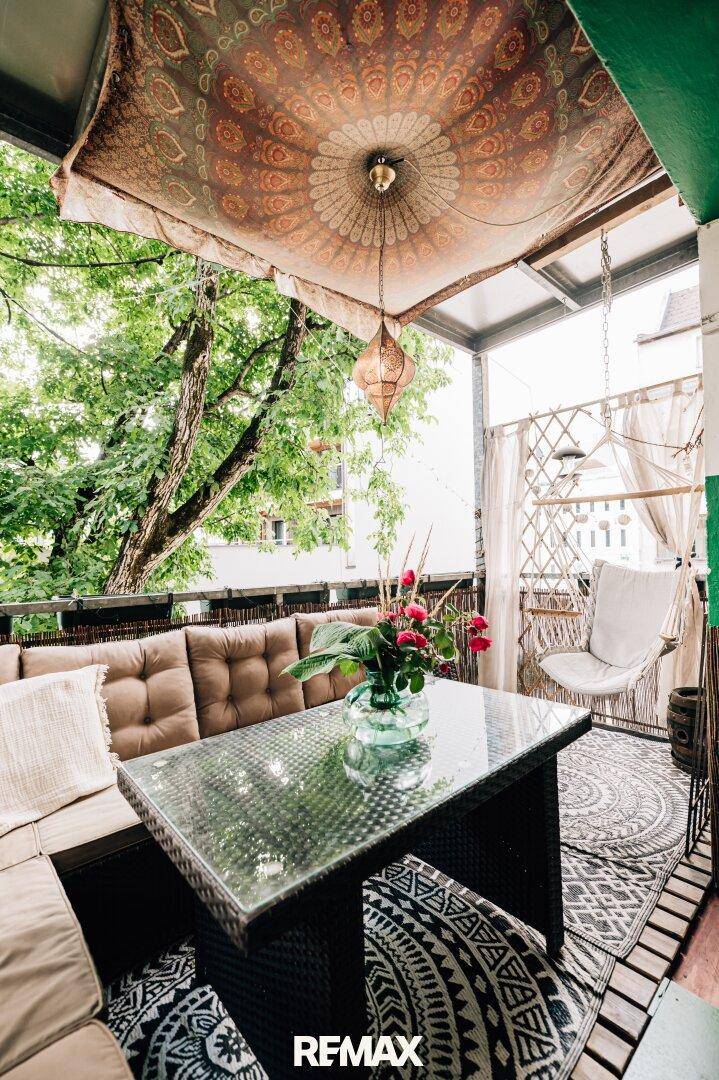 Gemütlicher Balkon mit Sitzgelegenheiten, orientalischem Dekor und viel Grünblick.