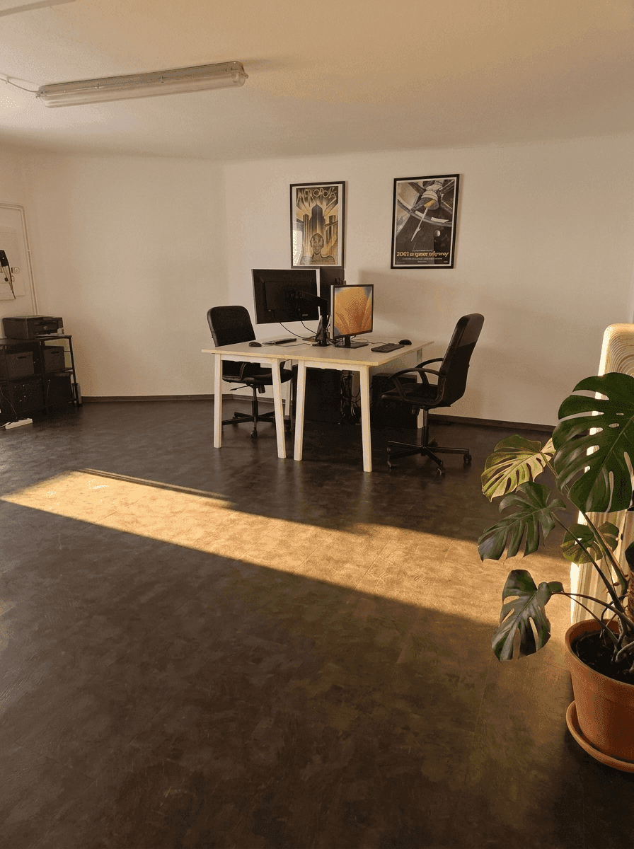 Geräumiges Büro mit zwei Arbeitsplätzen, Computern und natürlichem Lichteinfall.