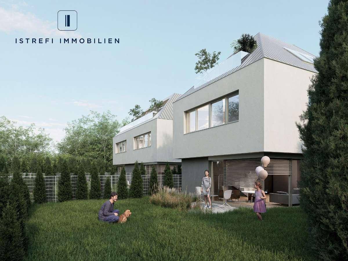 Gepflegter Gartenbereich mit Rasenfläche und Sitzgelegenheiten vor den modernen Reihenhäusern.