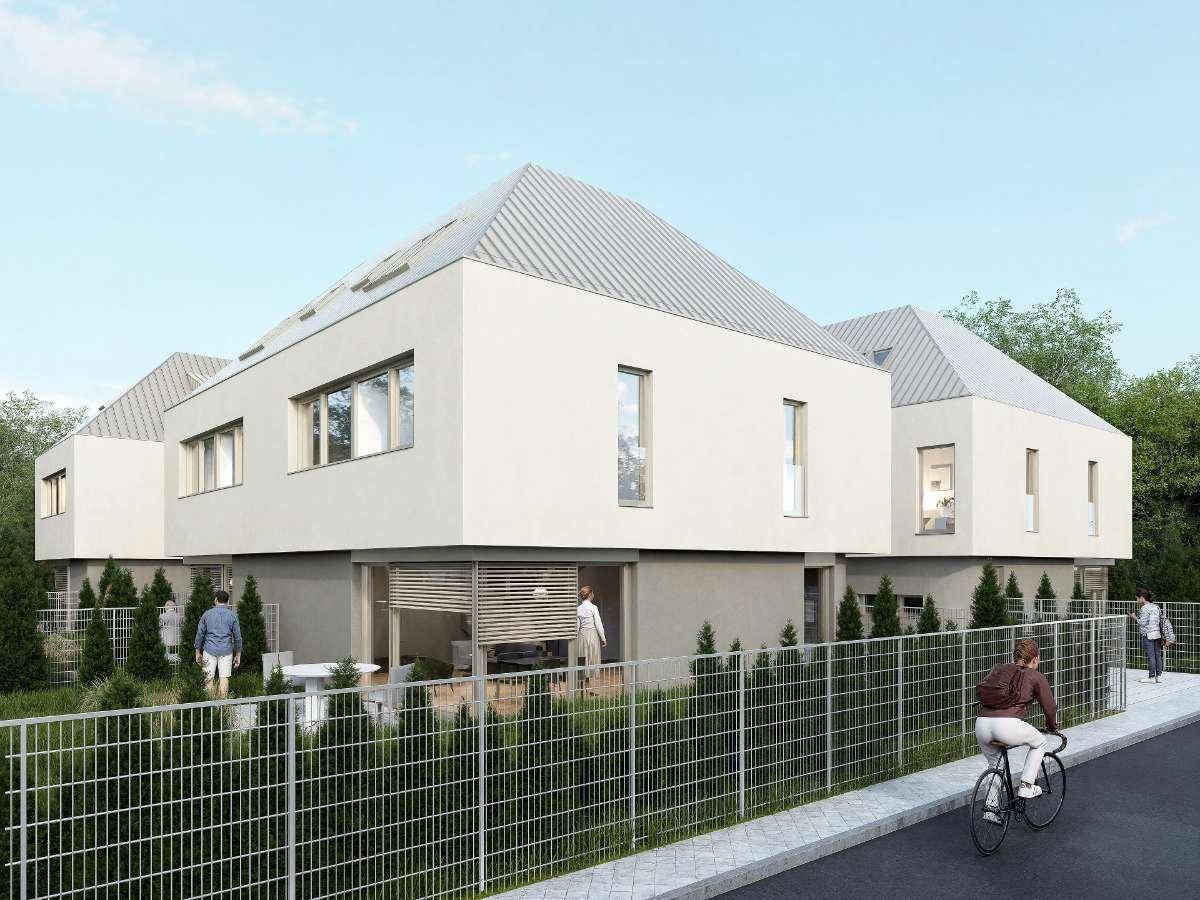 Seitenansicht der modernen Reihenhäuser mit großen Fenstern und gepflegter Außenanlage.