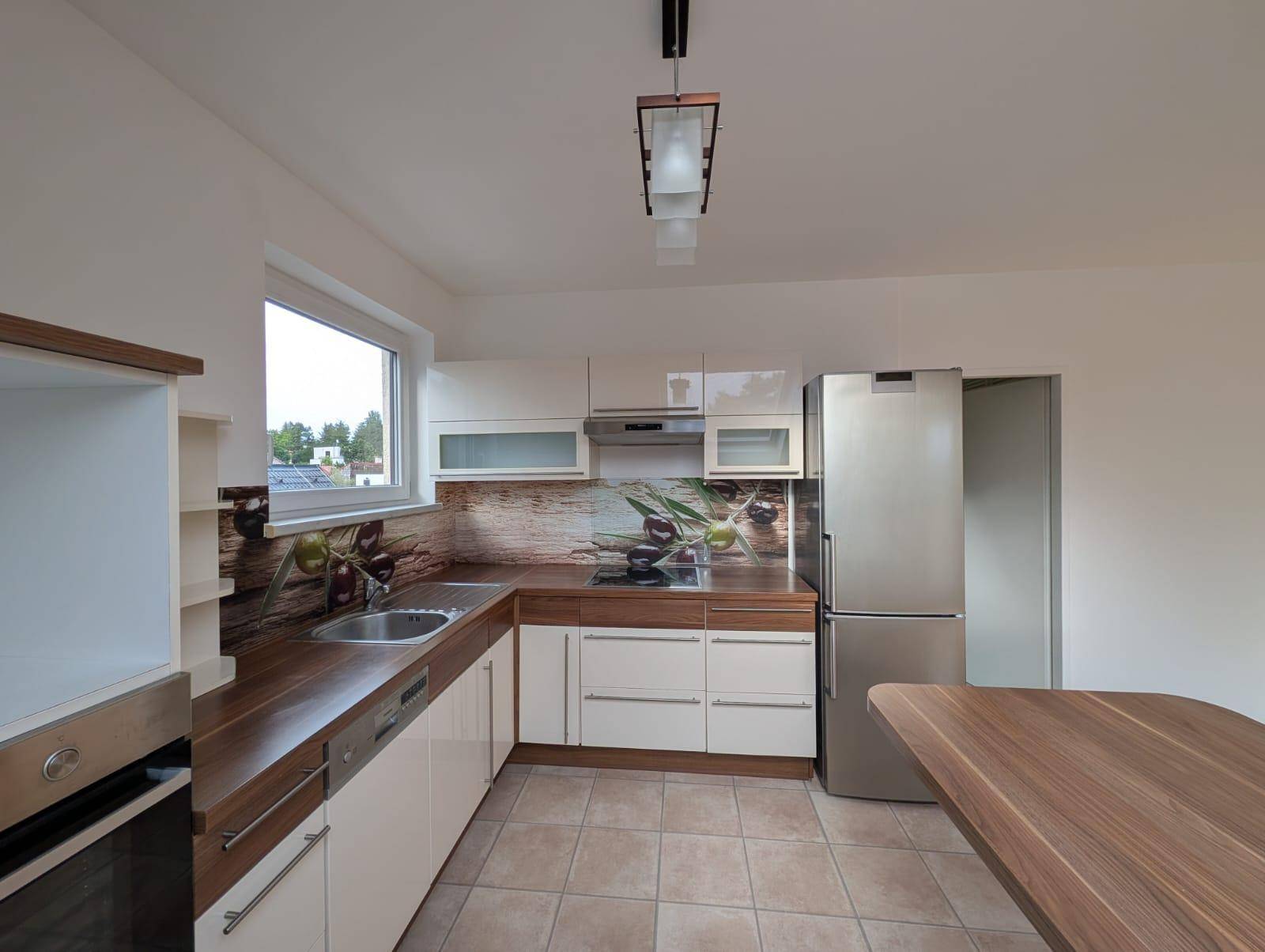 Einbauküche mit Holz-Arbeitsplatten, modernen Geräten und dekorativer Rückwand.