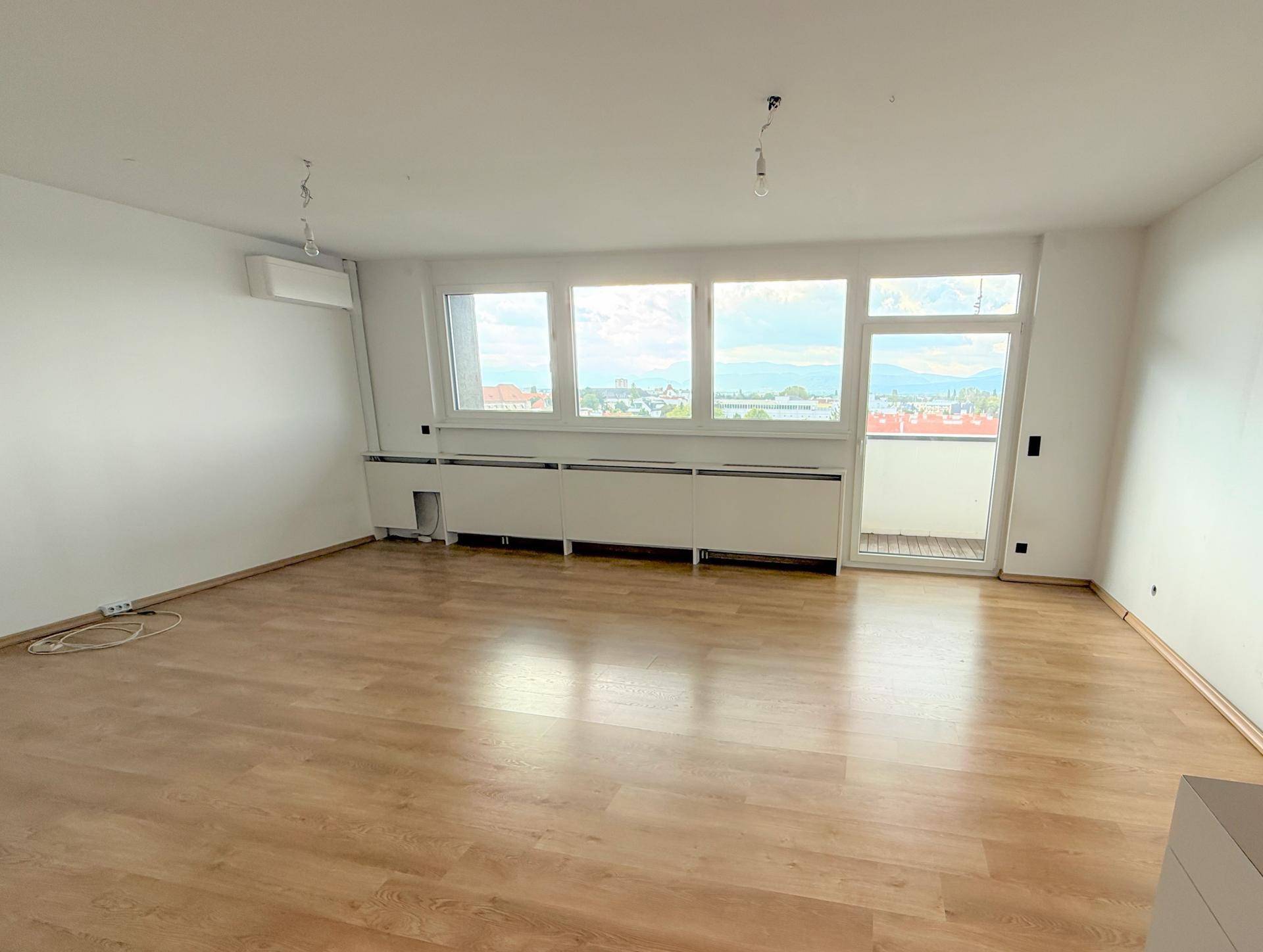 Geräumiges, helles Zimmer mit Holzboden, Klimaanlage und weitem Stadtblick.
