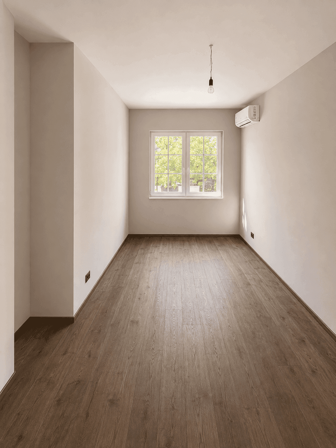 Schmaler, heller Raum mit Holzboden, Fenster und Klimaanlage, ideal als Schlafzimmer.