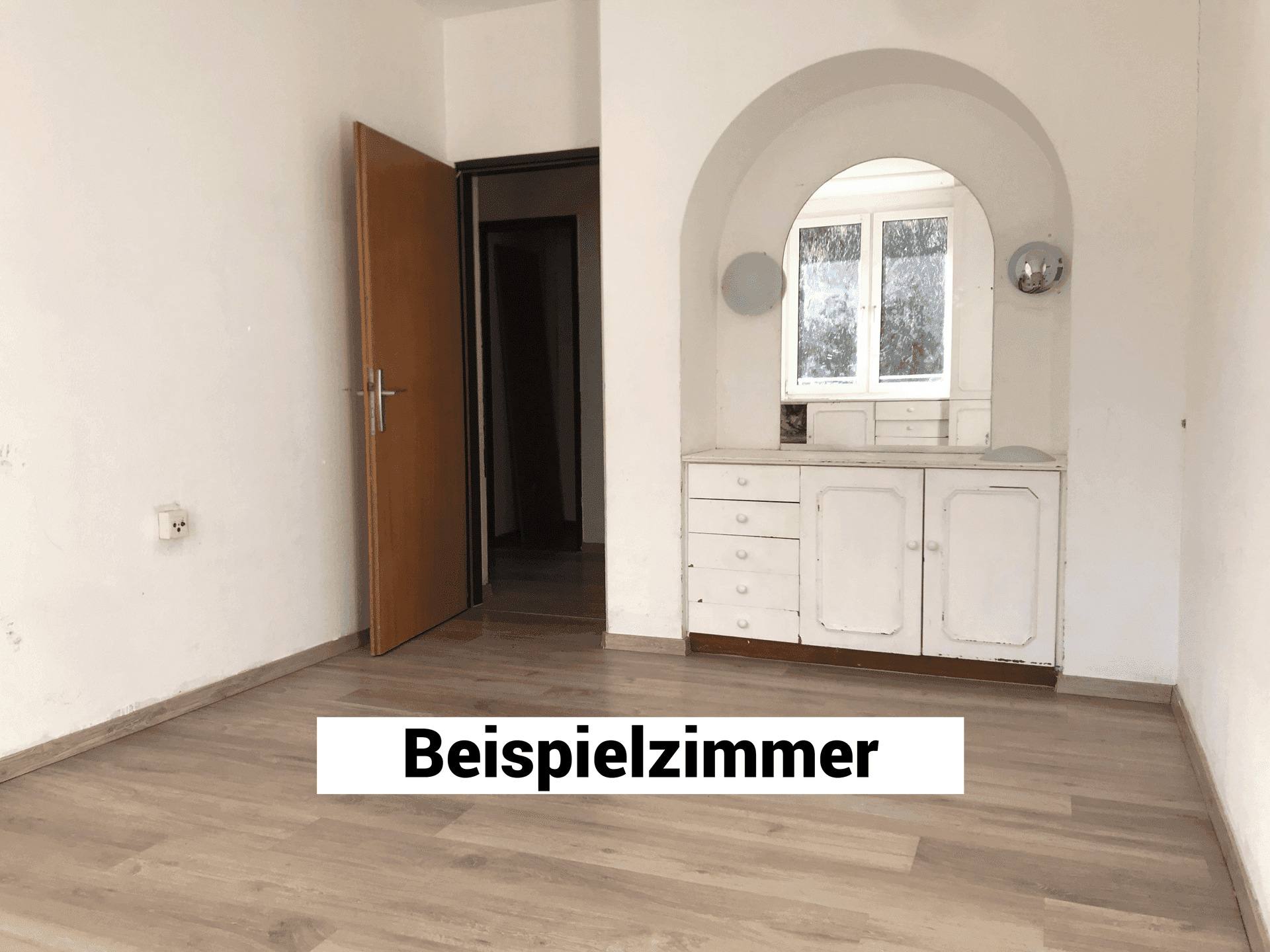 Leerer Raum mit Laminatboden und einem eingebauten Schrank in einer Nische.