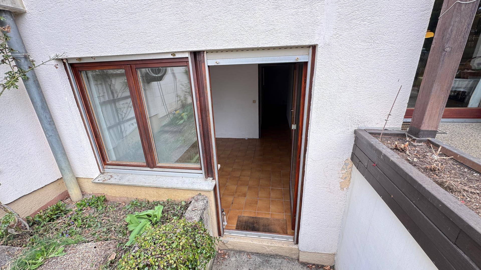 Eingang zu einem Zimmer auf Gartenebene mit Fliesenboden.