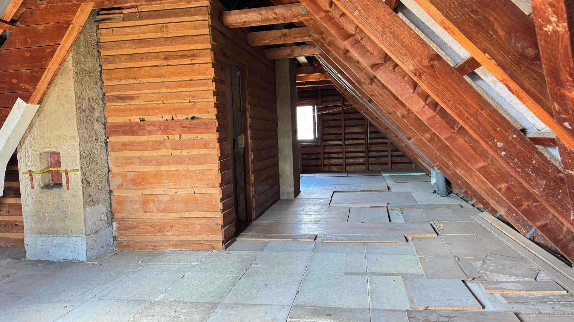 Dachboden mit sichtbaren Holzbalken und Holzverkleidung.