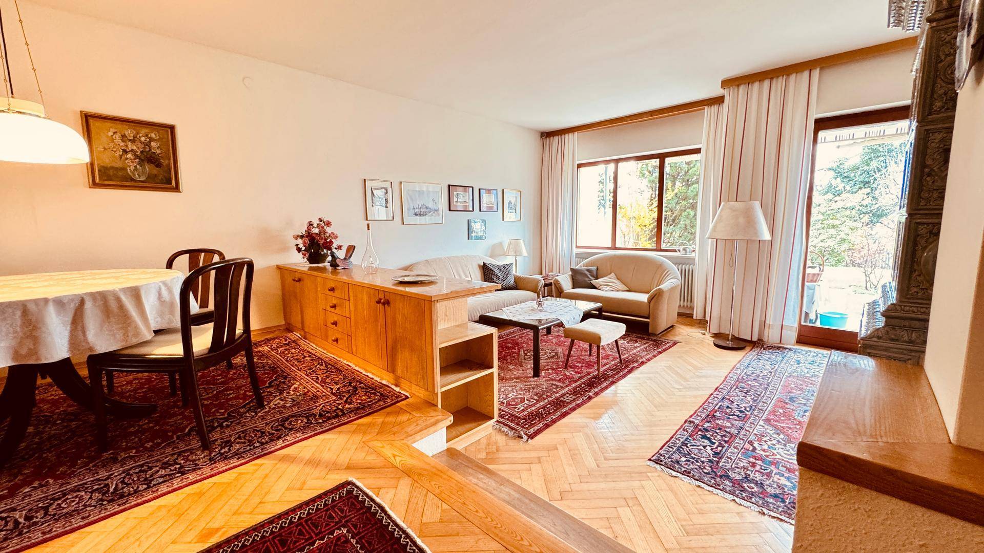 Geräumiger Wohn- und Essbereich mit Parkettboden und Zugang zur Terrasse.