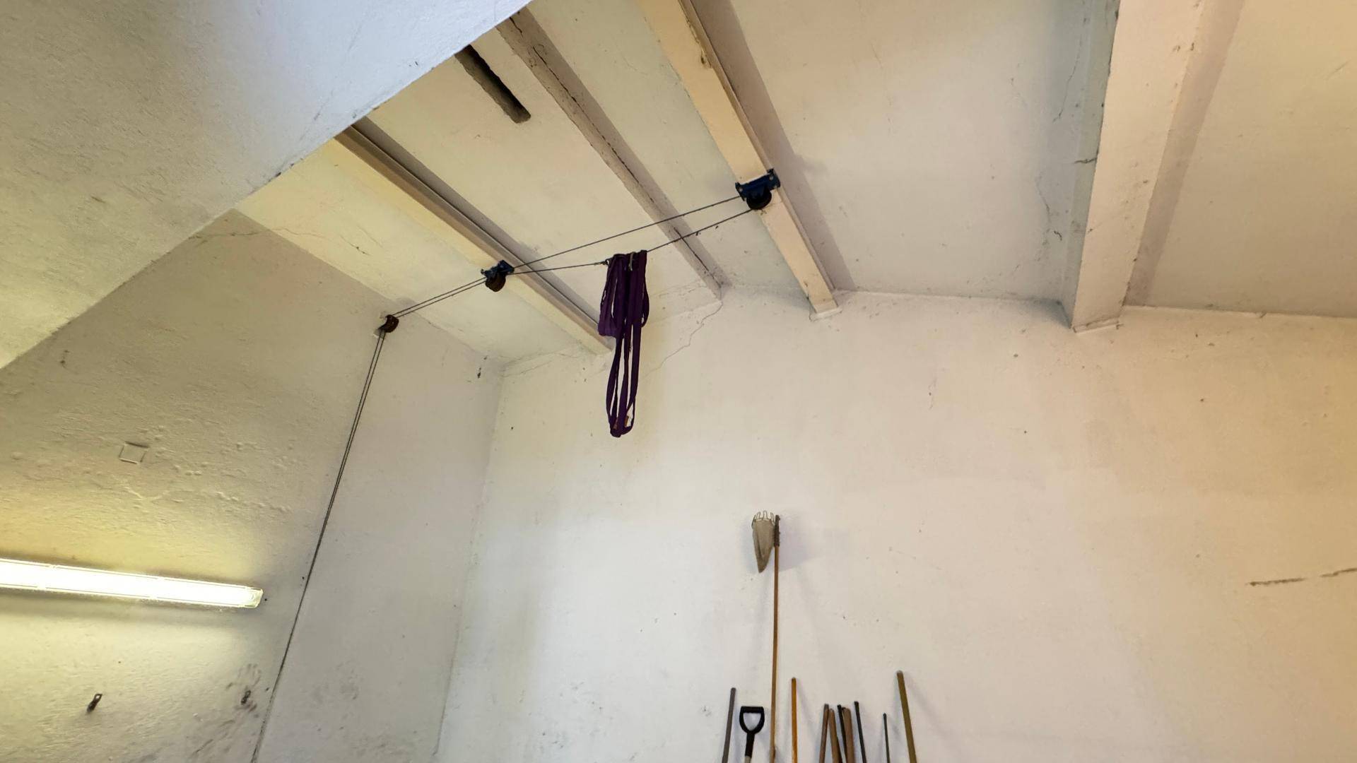 Garagendecke mit Beleuchtung und aufgehängten Werkzeugen.