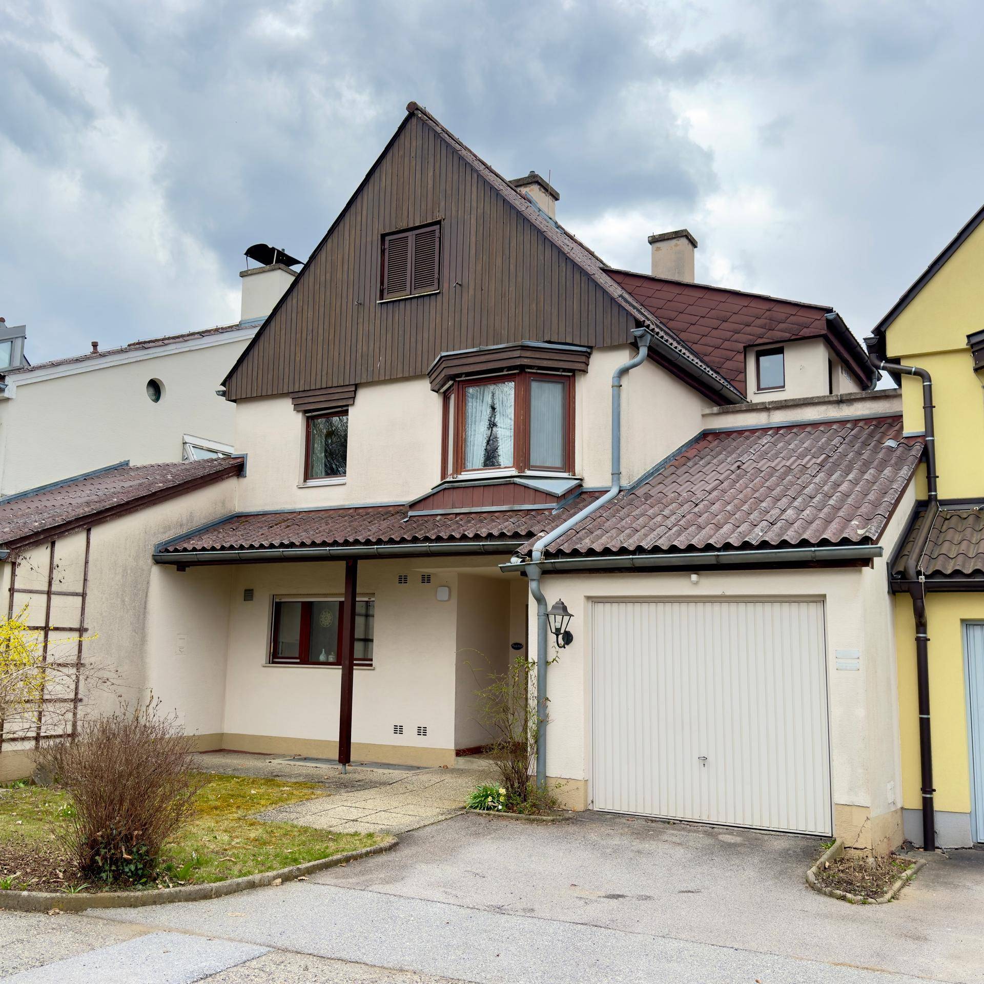 Vorderansicht des Hauses mit Garage, Eingangsbereich und Satteldach.