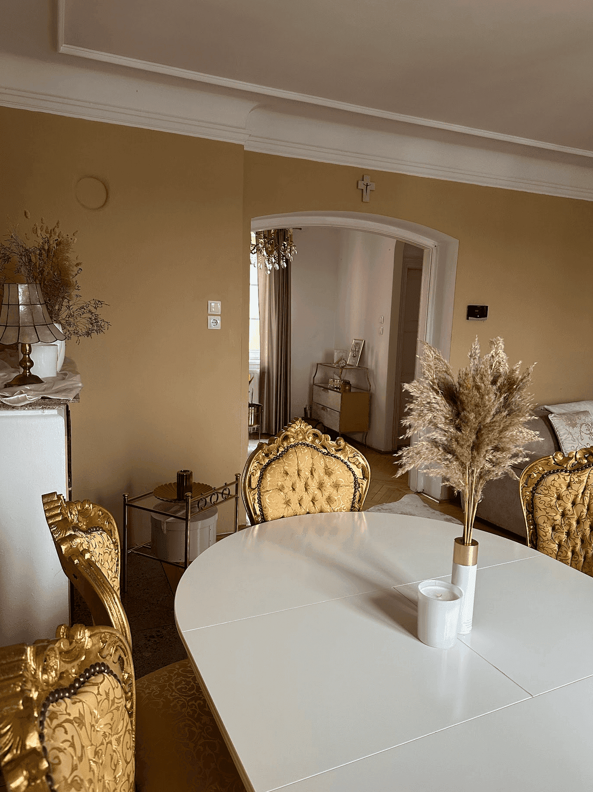 Eleganter Wohn-Essbereich mit Blick auf den Flur, ausgestattet mit goldenen Stühlen und einem Kronleuchter.