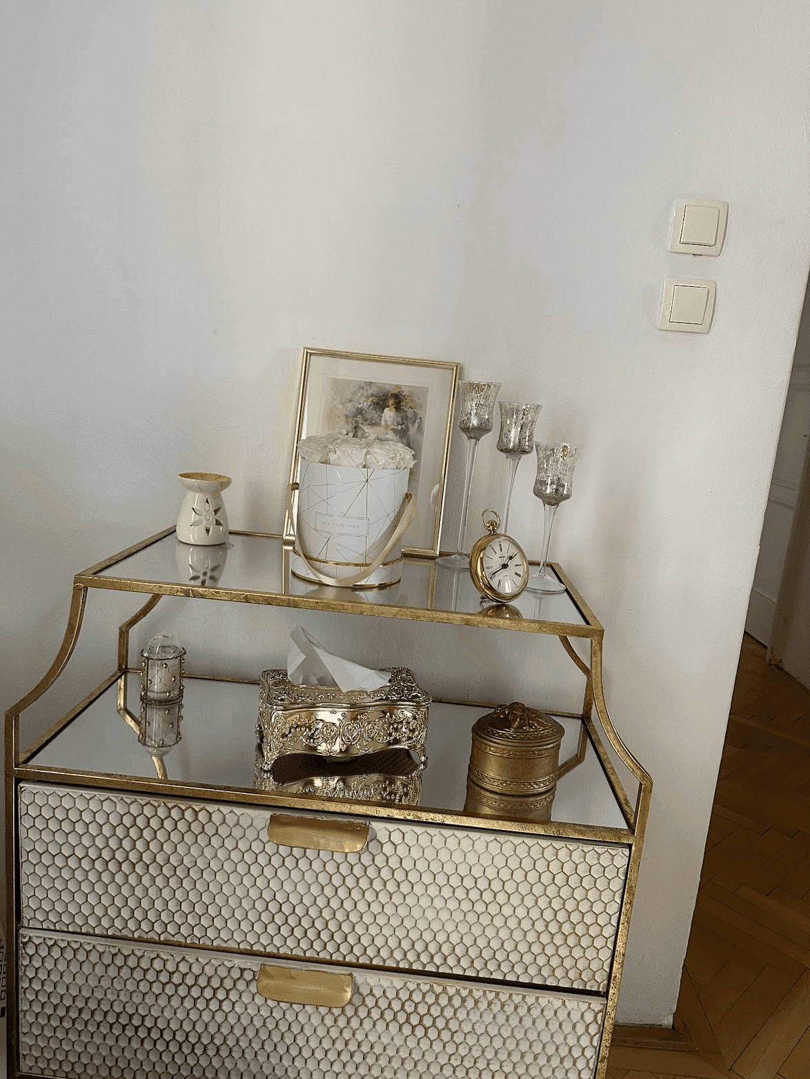 Dekorativer Beistelltisch mit Spiegeloberfläche und eleganten Accessoires im Flur.
