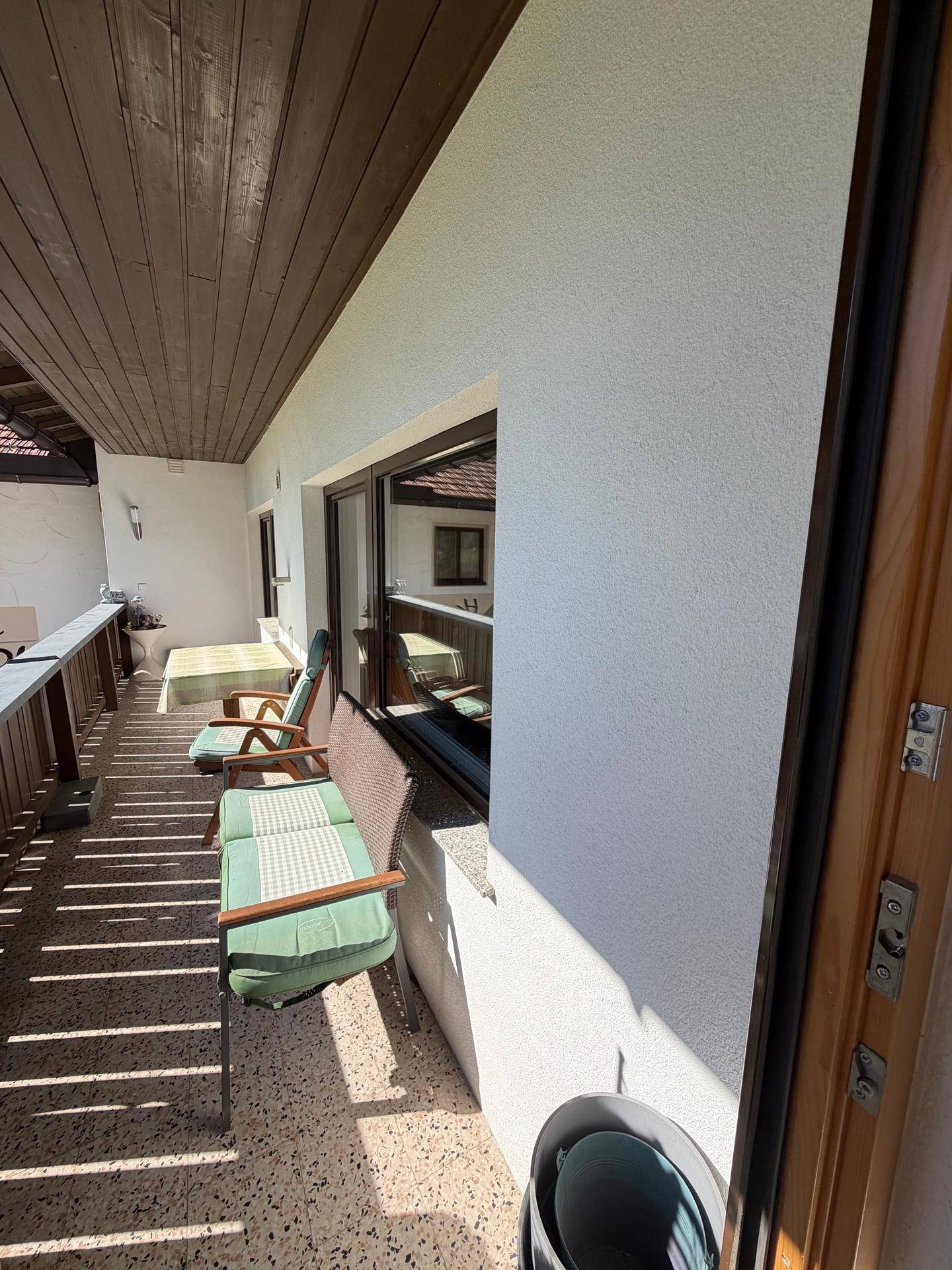 Langer Balkon mit Sitzgelegenheiten und Blick auf die umliegende Landschaft.