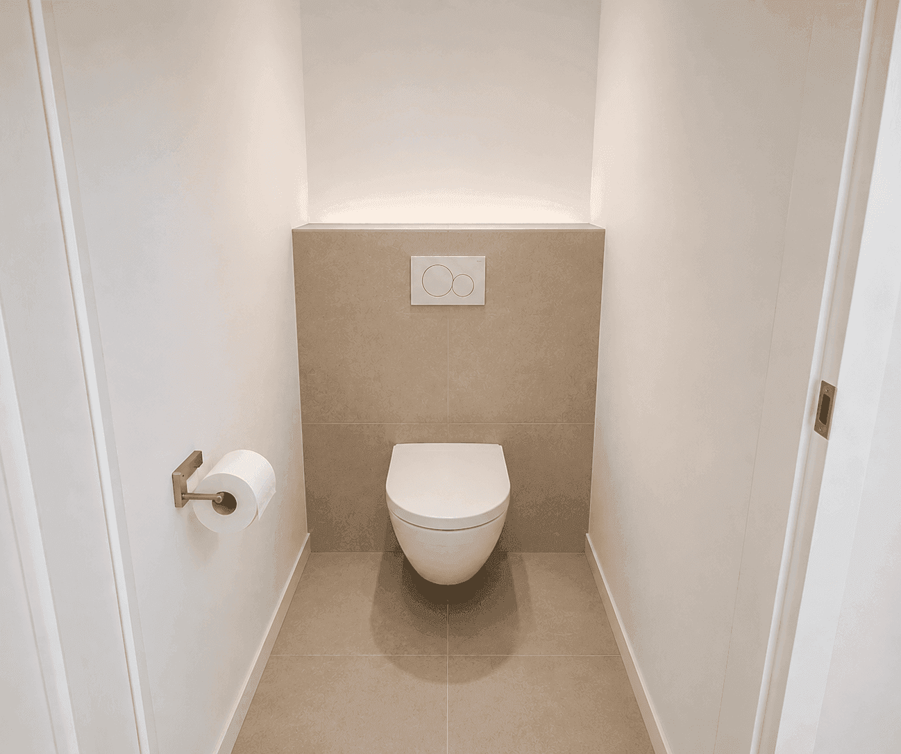 Separates WC mit wandhängender Toilette und modernen Fliesen.