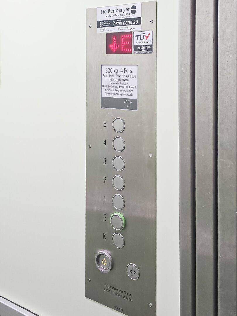 Aufzugbedienfeld mit Etagenauswahl und Informationen zur Tragfähigkeit des Lifts.