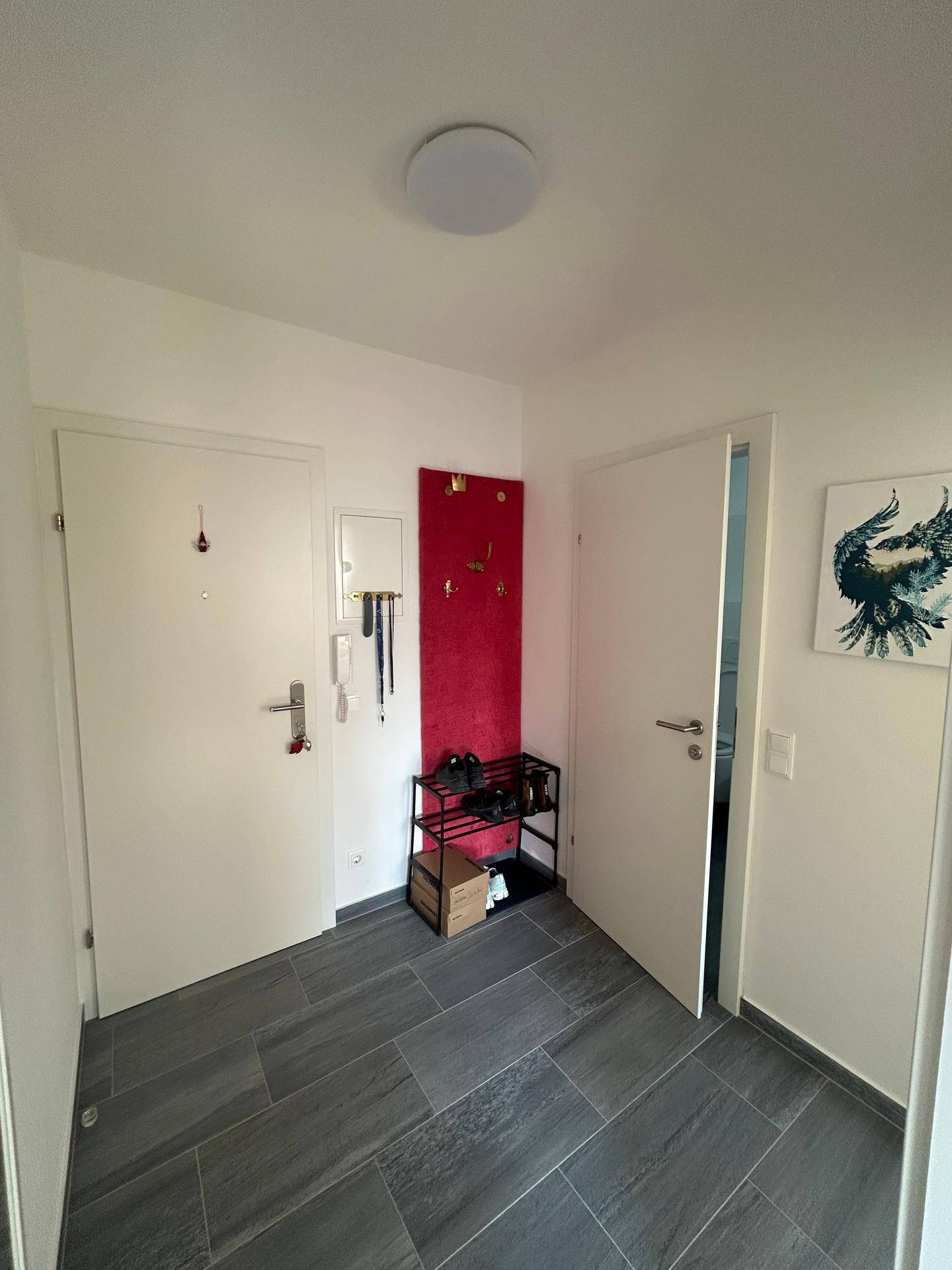 Eingangsbereich mit Fliesenboden, Garderobe und Zugang zu weiteren Räumen.