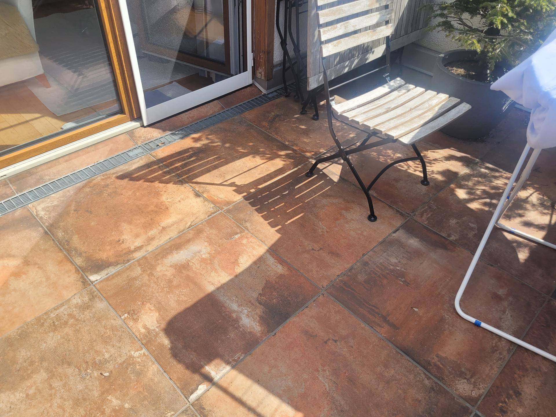 Sonnige Terrasse mit Terrakotta-Fliesenboden und Zugang zum Innenbereich.
