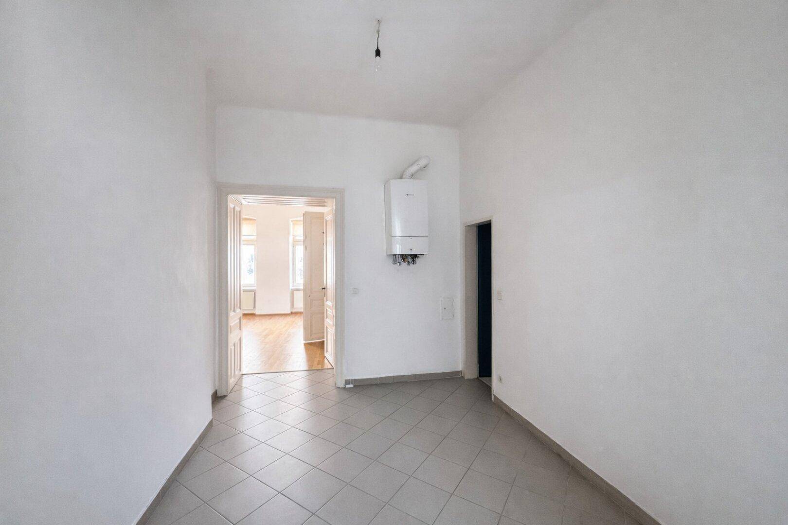 Funktionaler Raum mit Fliesenboden und Gastherme, ideal als Hauswirtschaftsraum.