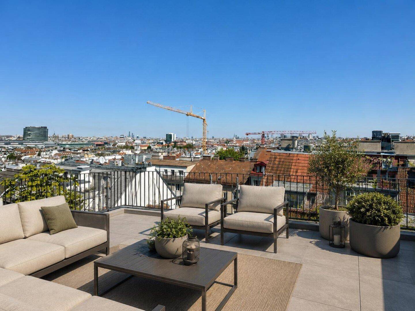 Geräumige Dachterrasse mit bequemen Loungemöbeln und weitem Blick über die Stadt.