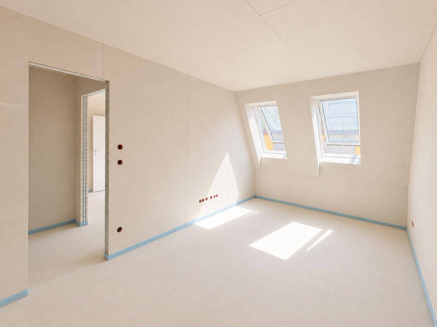Unfertiger Raum mit zwei Dachfenstern und viel Tageslicht, ideal für ein Schlafzimmer.