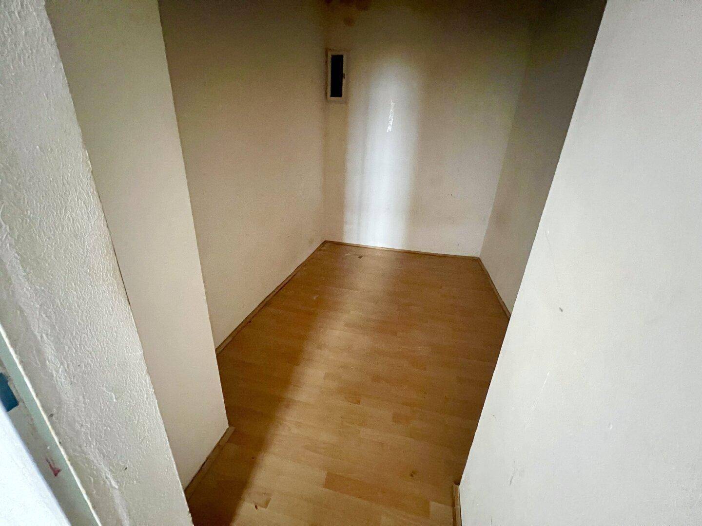 Kleiner, fensterloser Abstellraum mit hellem Laminatboden, ideal für zusätzlichen Stauraum.